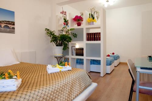 a bedroom with two beds and a shelf with flowers at Arena d'Intorno in Verona