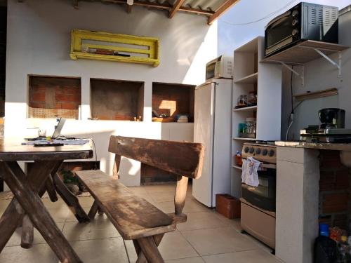 a kitchen with a wooden table and a wooden chair at Pousada Luz Beira mar in Tramandaí