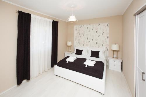 a bedroom with a white bed with black and white pillows at RELAXING HOME LUCE in Čilipi