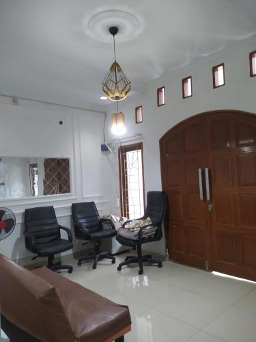 een wachtkamer met stoelen en een houten deur bij Homestay Propline in Bogor