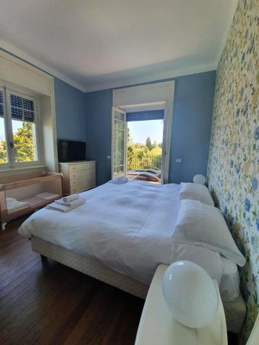 a bedroom with a large white bed and a window at Villa Angela in Stresa