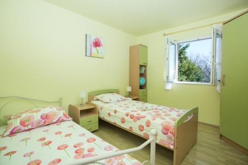 a bedroom with two beds and a window at RELAXING HOME LUCE in Čilipi