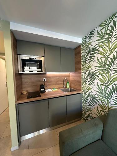 une cuisine avec un évier et un micro-ondes dans l'établissement MULTIRESIDENCE L'ELYSEE Paris, à Paris