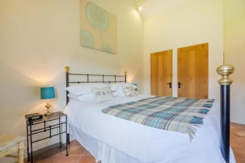 een slaapkamer met een groot wit bed en een tafel bij The Cart Lodge 6 in Great Massingham