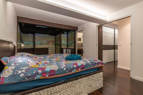 - une chambre avec un lit et une couverture colorée dans l'établissement Loft design & familial parc des Buttes Chaumont, à Paris