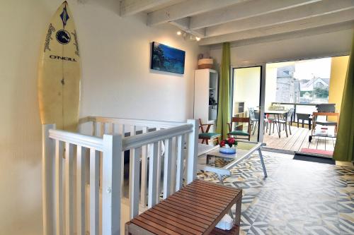 une chambre avec une planche de surf sur le mur et une terrasse couverte dans l'établissement Le Bernique - A 50 mètres de la plage, à Saint-Jacut-de-la-Mer