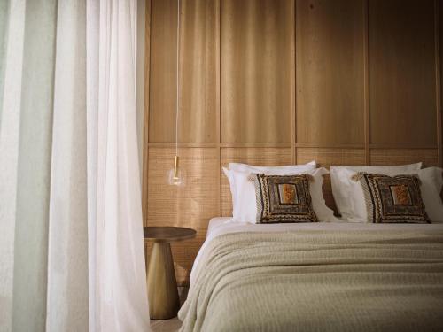 a bedroom with a bed and a table and curtains at Verdante Villas in Agios Nikolaos