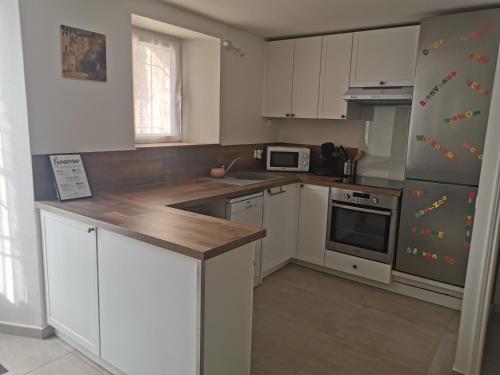 a kitchen with white cabinets and stainless steel appliances at Jas de Marripey in Les Arcs sur Argens