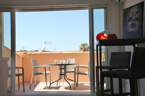 un patio avec une table et des chaises sur un balcon dans l'établissement Studio 550, Port Soleil au village naturiste, au Cap d'Agde