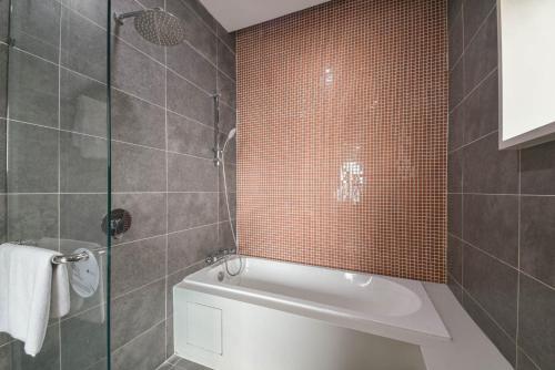 Damansara Perdana的住宿－PlayStaytion Damansara by RBNB，带浴缸和玻璃淋浴间的浴室。