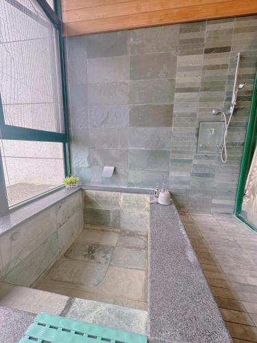 a bathroom with a tub and a shower at 天天泡湯 in Yilan City