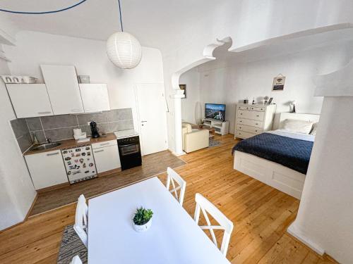 a bedroom with a bed and a table and a kitchen at The North Apartment in Ljubljana