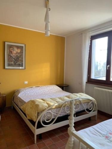a bedroom with a bed in a yellow wall at [Appartamento Girasole] in Varzi