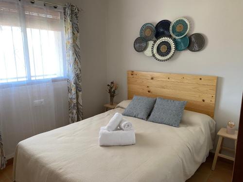 ein Schlafzimmer mit einem weißen Bett mit Hüten an der Wand in der Unterkunft Las Chorreras del Orejón 1 in Villaviciosa de Córdoba