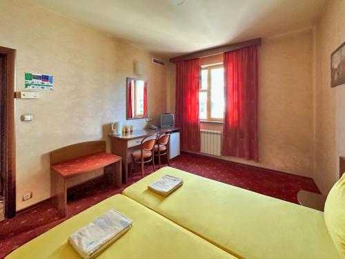 Cette chambre comprend un lit, une table et un bureau. dans l'établissement Hotel Rai, à Sofia
