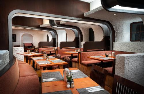 a restaurant with wooden tables and chairs in a train at elaya hotel stuttgart ludwigsburg ehemals Abacco by Rilano in Korntal-Münchingen