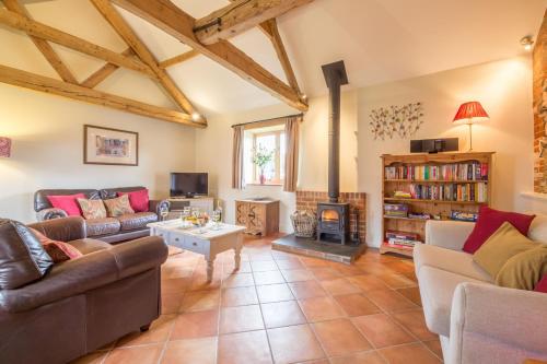 a living room with two couches and a fireplace at The Dairy in Great Massingham