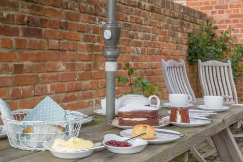 a wooden table with plates of food on it at The Dairy in Great Massingham