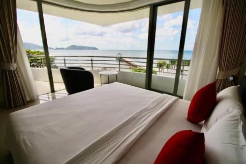 a bedroom with a bed with a view of the ocean at Luxury Rooftop Penthouse in Ban Nakhale