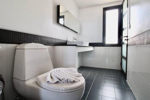 a bathroom with a white toilet and a sink at Luxury Rooftop Penthouse in Ban Nakhale
