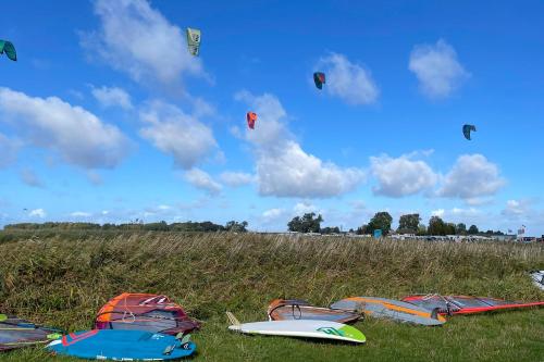 a group of kites flying in the sky over a field at Ferienhaus am kleinen Hafen in Neuendorf
