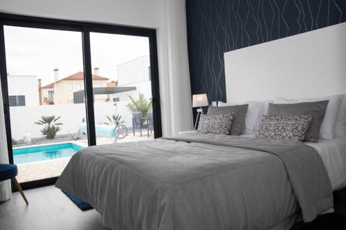 um quarto com uma cama e uma grande janela com uma piscina em Villa Besugo - SCH082 em Pataias