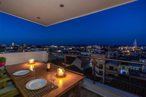 einen Balkon mit einem Tisch mit Weingläsern und Kerzen in der Unterkunft Zama Suites in Zakynthos