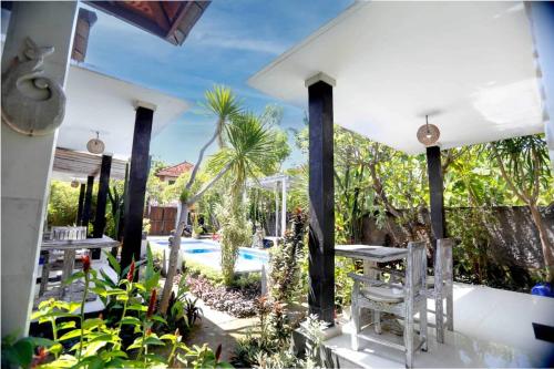 eine Terrasse mit Tisch und Stühlen und einem Pool in der Unterkunft Belvilla Ananda Resort Lovina BeachNearPantai Lovina in Lovina