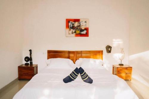 ein weißes Bett mit zwei Paar Schuhen drauf in der Unterkunft Belvilla Ananda Resort Lovina BeachNearPantai Lovina in Lovina