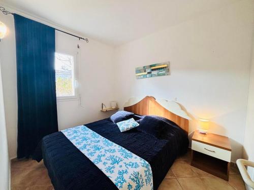 a bedroom with a bed with blue sheets and a window at Appartement Boug 26 Lumio in Lumio