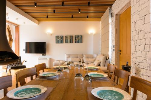 a dining room with a wooden table and chairs at Casa di Plaka in Elounda