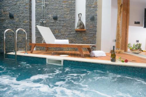 a swimming pool with a bench and a chair at Casa di Plaka in Elounda