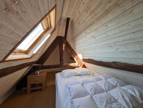 2 Betten in einem Dachzimmer mit Fenster in der Unterkunft Plage & Marais - Maison 3 chambres 6 personnes - in Guérande