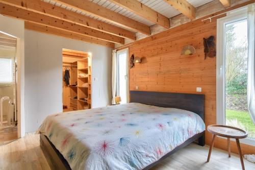 une chambre avec un lit dans une pièce aux murs en bois dans l'établissement Maison moderne avec jardin pour 12 personnes, à Saint-Jean-de-Monts
