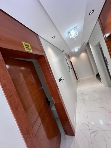 Un pasillo con una puerta de madera en un edificio. en شقق شهم المفروشه, en Abha