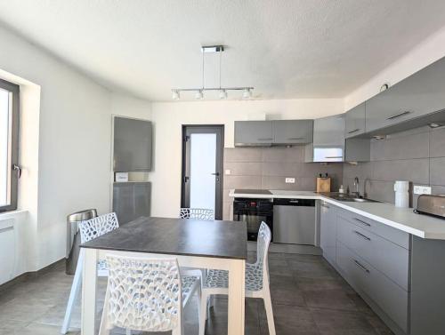 une cuisine avec une table et des chaises dans l'établissement Plage & Marais - Maison 3 chambres 6 personnes -, à Guérande