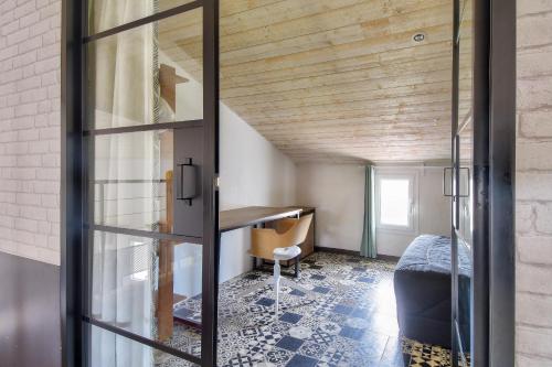 une chambre avec un bureau, un lit et une porte vitrée dans l'établissement Maison moderne avec jardin pour 12 personnes, à Saint-Jean-de-Monts