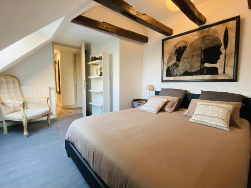 um quarto com uma cama grande e uma cadeira em Le Pigeonnier em Rodez
