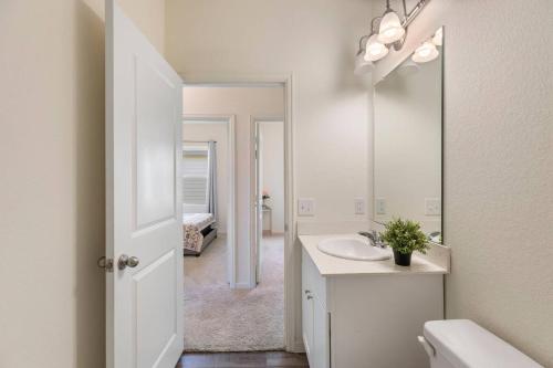 Baño blanco con lavabo y espejo en Your cozy home in Brookshire, 