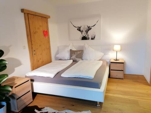1 dormitorio con 1 cama con una vaca en la pared en Haus Miriam en Mieming