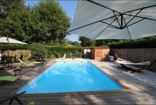 - une piscine avec un hamac et un parasol dans l'établissement Séjour apaisant avec piscine à Andernos-les-Bains, à Andernos-les-Bains