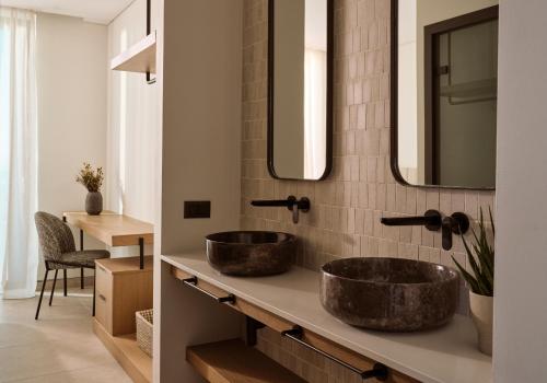 a bathroom with two sinks and a mirror at Verdante Villas in Agios Nikolaos
