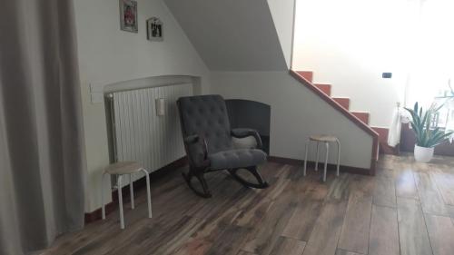 a chair and two stools in a room with stairs at B&B Villa Angela Via della bonifica 17 in Villareia