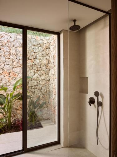 a bathroom with a shower with a glass door at Verdante Villas in Agios Nikolaos