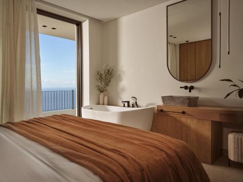 a bathroom with a bed and a tub and a sink at Verdante Villas in Agios Nikolaos