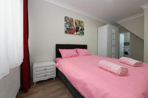 a bedroom with a pink bed with pink pillows at Uzay Suite 1 in Istanbul