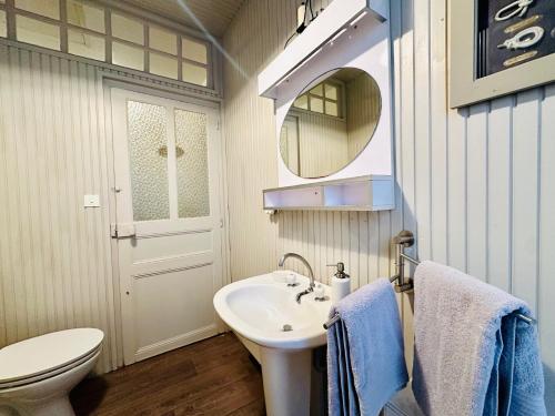une salle de bain avec un lavabo, des toilettes et un miroir dans l'établissement Maison cœur de ville Les Sables d Olonne 5 personnes, à Les Sables-dʼOlonne