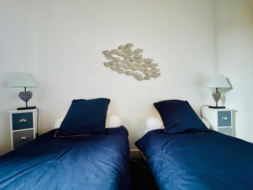 - 2 lits dans une chambre avec des draps et des lampes bleus dans l'établissement Maison cœur de ville Les Sables d Olonne 5 personnes, à Les Sables-dʼOlonne