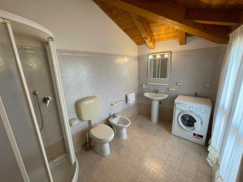 y baño con lavamanos y lavadora. en Residence Mediterraneo - Agenzia Cocal, en Caorle