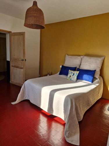 a bedroom with a large bed with blue pillows at Mas de la Sorgue - Rendez-vous en Provence in Bédarrides